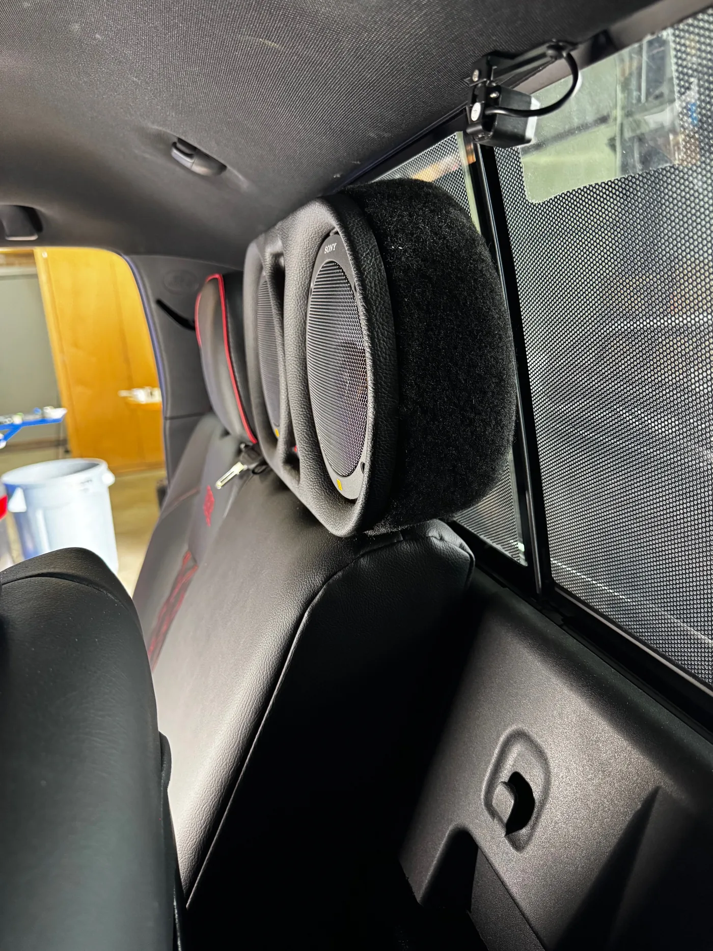 Close-up of a custom carpeted rear-seat speaker pod, 2023 Toyota Tacoma