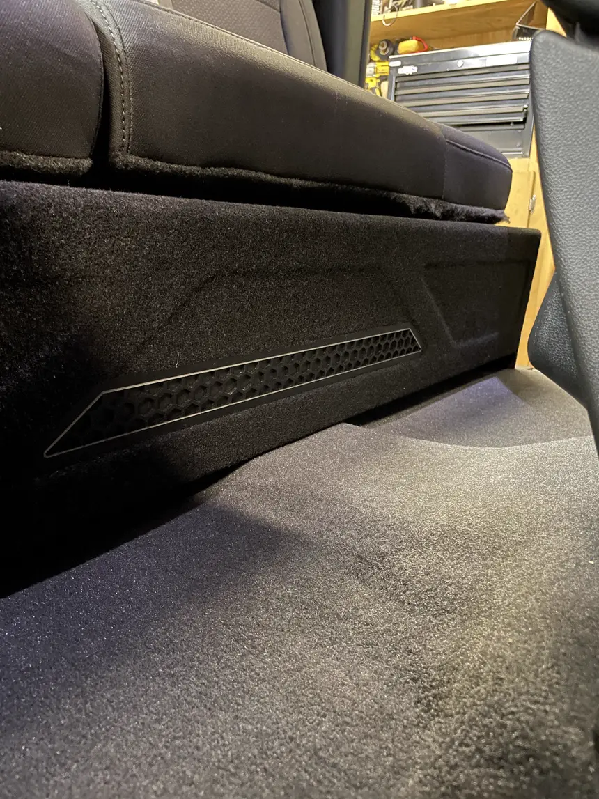 Behind-seat custom truck subwoofer enclosure carpeted to match the interior, by Xclusive Autosound, Belleville IL
